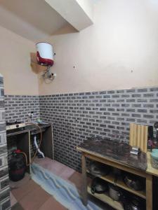 a room with a brick wall with a table in it at Maddy's Guest House in Guwahati