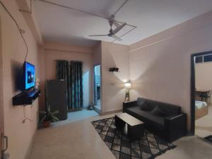 a living room with a couch and a tv at Maddy's Guest House in Guwahati