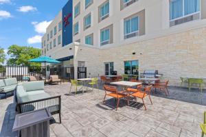 a patio with tables and chairs in front of a hotel at Hampton Inn By Hilton Wharton in Wharton
