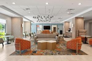 a lobby with a couch and tables and chairs at Hampton Inn By Hilton Wharton in Wharton