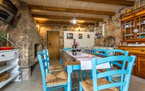 a dining room with a blue table and chairs at Villa Cima in Vrbnik