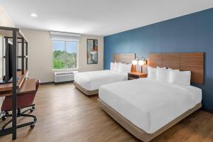 a hotel room with two beds and a desk at Everhome Suites Georgetown - Austin in Georgetown +57 photos