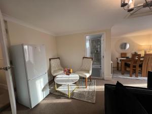 a kitchen with a refrigerator and a table and chairs at Summerhill by suspire in Ashford