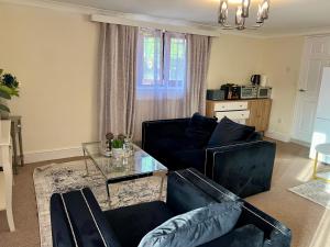 a living room with a couch and a glass table at Summerhill by suspire in Ashford