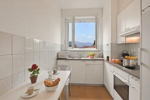 a white kitchen with a table and a window at Bellinzona Center in Bellinzona