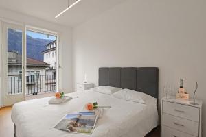a bedroom with a large white bed with a window at Bellinzona Center in Bellinzona