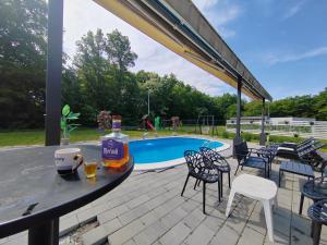 a bottle of alcohol on a table next to a pool at Jerry's Forest in Banja Luka
