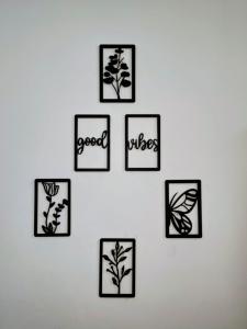 a white wall with black framed pictures of plants at Calm Corner in Panchkula