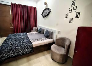 a bedroom with a bed and a chair at Calm Corner in Panchkula