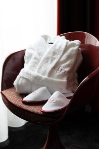 a chair with towels and slippers on it at Chapeau Rouge par William Frachot - Hôtel Espace Bien-être & Restaurant étoilé in Dijon +141 photos