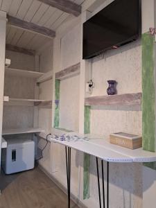 a room with a table and a tv on a wall at Căsuța Vesela in Cernişoara
