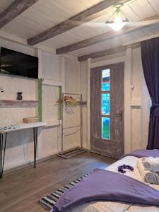 a room with a bed and a desk and a window at Căsuța Vesela in Cernişoara