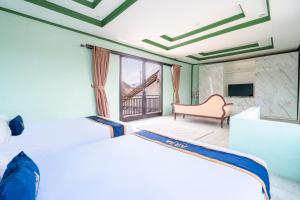 a hotel room with two beds and a couch at Villa Malakai By ARBA in Palayangan