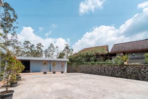 a courtyard of a house with a stone wall at Villa Malakai By ARBA in Palayangan