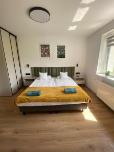 a bedroom with a large bed with a yellow blanket at SKALNY apartamenty, pokoje - Ogród, Spokój i Natura in Ogrodzieniec