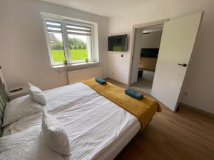 a bedroom with a large bed with a yellow blanket on it at SKALNY apartamenty, pokoje - Ogród, Spokój i Natura in Ogrodzieniec
