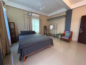 a bedroom with a large bed and a chair at Aika Homestay in Pāsighāt