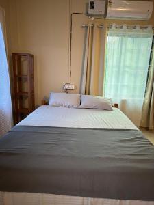 a large bed in a room with a window at Aika Homestay in Pāsighāt +3 photos