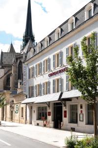 a building on the side of a street with a church at Chapeau Rouge par William Frachot - Hôtel Espace Bien-être & Restaurant étoilé in Dijon