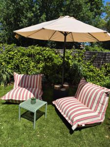 two chairs and an umbrella in a yard at L orangerie de casaoma in Prunelli-di-Fiumorbo