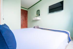 a room with a couch and a tv on a wall at Villa Malakai By ARBA in Palayangan +25 photos