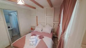 a bedroom with a bed with two stuffed animals on it at Căsuța Veselă in Tătuleşti +5 photos