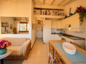 a kitchen and living room with a couch and a table at Amazing Sea View Terrace A with Pool 70m from the Beach in Baja Sardinia
