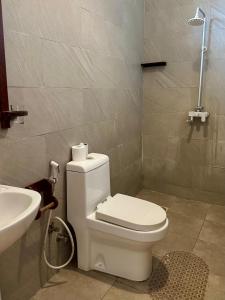 a bathroom with a white toilet and a sink at vayana nungwi in Nungwi