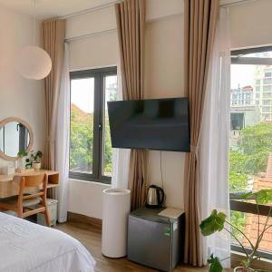 a bedroom with a bed and a flat screen tv at Glory 2 Hue Homestay in Hue