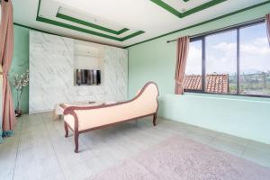 a living room with a bench and a tv at Villa Malakai By ARBA in Palayangan