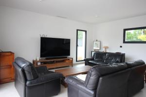 a living room with two leather chairs and a flat screen tv at Villa d exception piscine privée 200m2 10 pers RESTONICA Les Terrasses de Ruppione in Pietrosella
