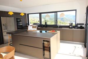 a kitchen with a large island in the middle at Villa d exception piscine privée 200m2 10 pers RESTONICA Les Terrasses de Ruppione in Pietrosella