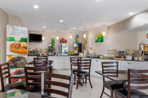 a restaurant with tables and chairs and a kitchen at Quality Inn McComb in McComb