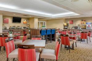 a restaurant with tables and chairs and a tv at Comfort Suites Gastonia - Charlotte in Gastonia
