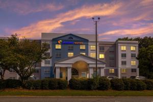 a hotel with a sign on the front of a building at Comfort Suites Gastonia - Charlotte in Gastonia