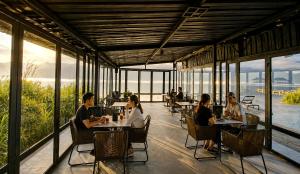 a group of people sitting at tables in a restaurant at Inap Retreat Boutique Cabin Kintamani in Kubupenlokan