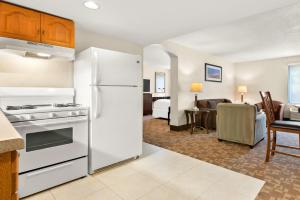 a kitchen with a white refrigerator and a living room at Quality Inn Edison-New Brunswick in Edison