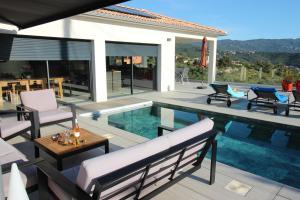 a villa with a swimming pool and a patio at Villa d exception piscine privée 200m2 10 pers RESTONICA Les Terrasses de Ruppione in Pietrosella