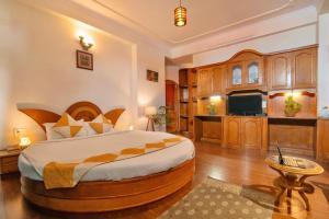 a large bedroom with a large bed and a kitchen at Cedar Cottage in Shimla +86 photos