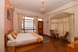 a bedroom with a bed and a table and a window at Cedar Cottage in Shimla