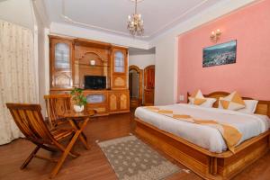a bedroom with a large bed and a table and chair at Cedar Cottage in Shimla