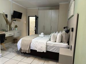 ein Schlafzimmer mit einem Bett mit weißen Laken und Kissen in der Unterkunft Koi liv-Inn Bedfordview ll Modern Guest House Near OR Tambo in Bedfordview