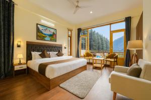 a hotel room with a bed and a large window at Hotel The Winterline - Best Selling Property in Kasol 2025-26 in Kasol