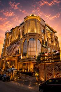 ein großes Gebäude vor dem Hintergrund eines Sonnenuntergangs in der Unterkunft Hotel Harmony Inn in Meerut