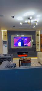 a living room with a couch and a tv at Vineyardcourts Apartment in Lagos