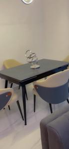 a black table with chairs and glasses on it at Vineyardcourts Apartment in Lagos