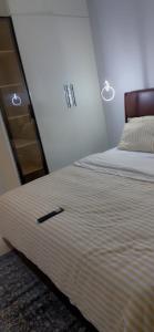 a bedroom with a bed with a black stick at Vineyardcourts Apartment in Lagos