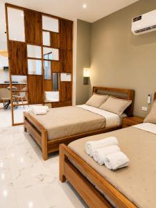 a bedroom with two beds with towels on them at Islander Suite in Puerto Baquerizo Moreno