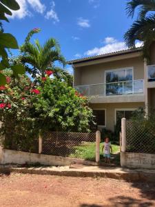 a little girl standing in front of a house at Covil das Trilhas Coliving SÓ PARA MULHERES in Lençóis