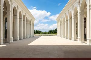 an empty corridor of a building with white columns at NDC Resort & Spa in Manado